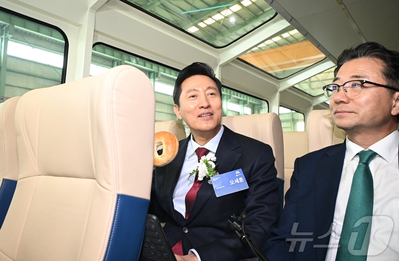 본문 이미지 - 오세훈 서울시장이 25일 &#39;한강 버스&#39; 내부 좌석에 앉아 베이글을 먹는 모습. 우측은 주용태 서울시 미래한강본부장. &#40;서울시 제공&#41;ⓒ 뉴스1