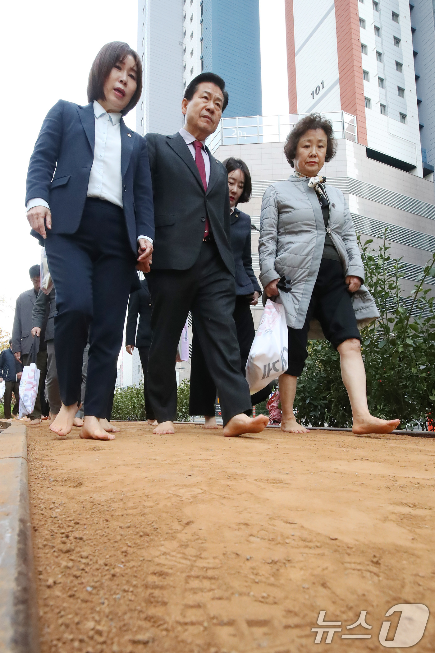 (대구=뉴스1) 공정식 기자 = 25일 오후 대구 중구보건소 북편 철도변에서 열린 '중구 도시숲 맨발산책로' 개장식에서 류규하 중구청장(앞줄 가운데)을 비롯한 참석자들이 맨발로 산 …