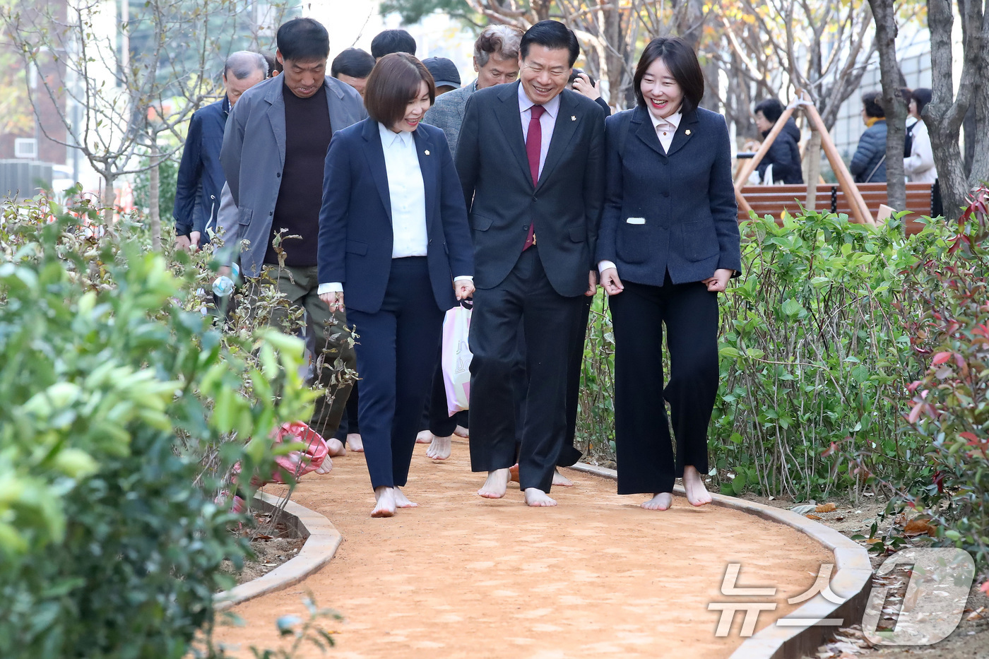 (대구=뉴스1) 공정식 기자 = 25일 오후 대구 중구보건소 북편 철도변에서 열린 '중구 도시숲 맨발산책로' 개장식에서 류규하 중구청장(앞줄 가운데)을 비롯한 참석자들이 맨발로 산 …