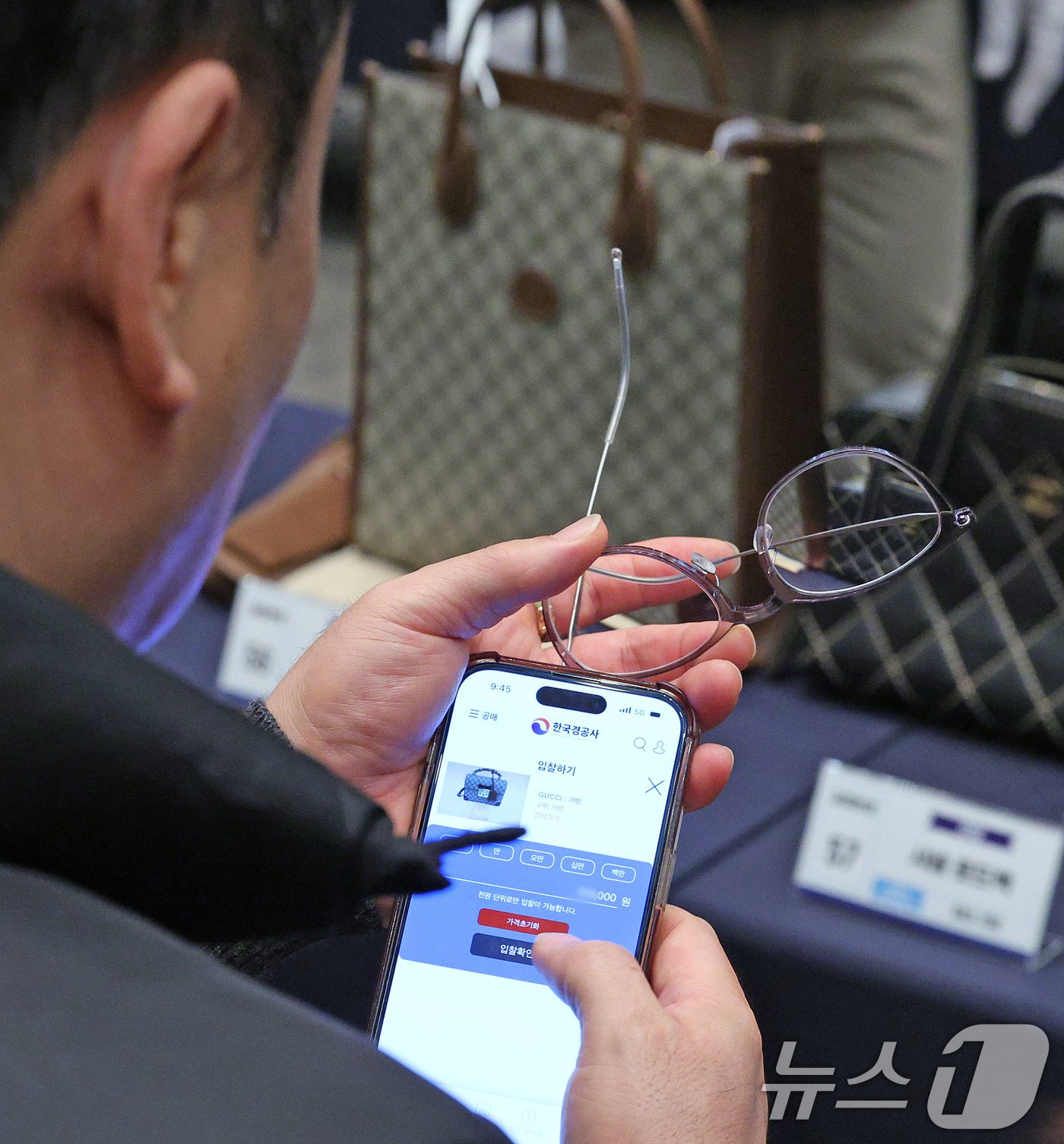 본문 이미지 - 26일 오전 경기 고양시 킨텍스에서 열린 '2024년 지방세 체납자 압류 동산 공매' 행사장을 찾은 시민이 명품가방 입찰을 하고 있다. 2024.11.26/뉴스1 ⓒ News1 장수영 기자