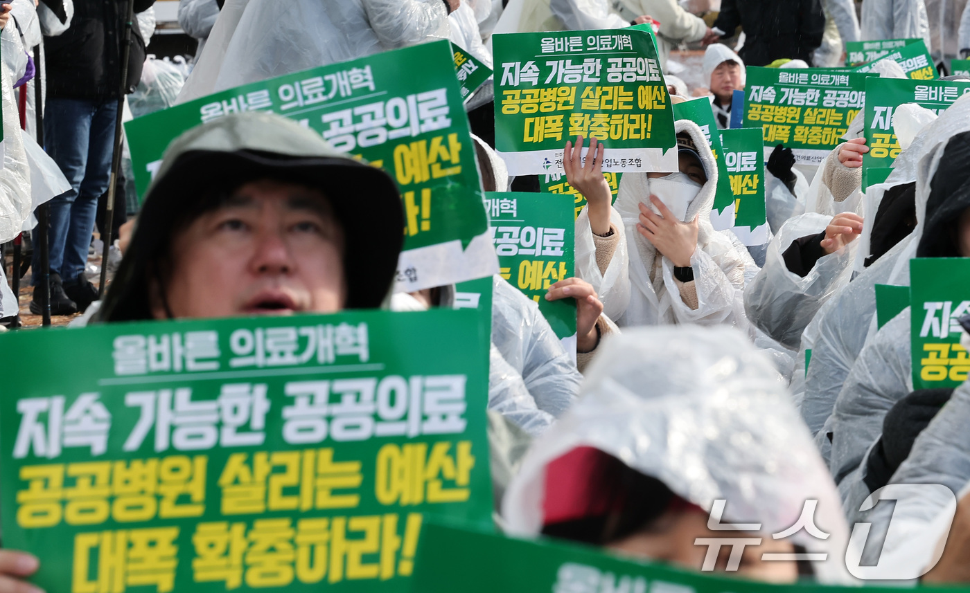 (서울=뉴스1) 김성진 기자 = 전국보건의료산업노동조합 조합원들이 26일 서울 영등포구 여의도 국회 앞에서 열린 공공병원 기능 회복‧역량 강화 촉구 결의대회에서 손피켓을 들고 구호 …