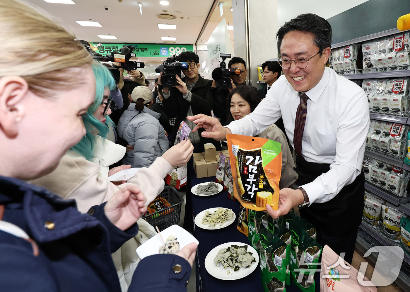 (서울=뉴스1) 구윤성 기자 = 강도형 해양수산부 장관이 26일 오후 서울 중구 롯데마트 제타플렉스 서울역점에서 김 수출액 역대 최고기록 경신을 기념해 관광객들에게 김으로 만든 주 …