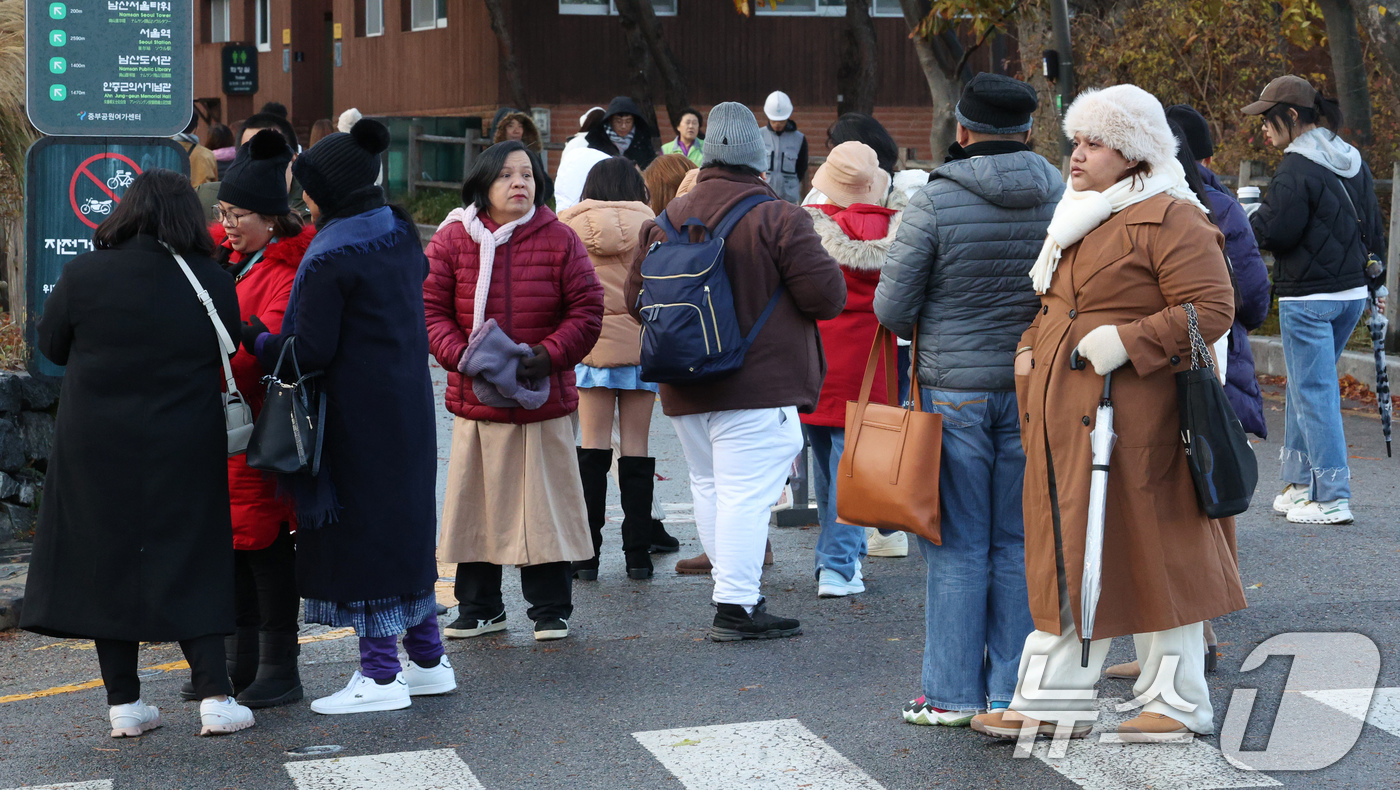 (서울=뉴스1) 장수영 기자 = 26일 오전 서울 중구 남산을 찾은 외국인 관광객들이 두꺼운 옷을 껴입고 있다.기상청은 이날 전국에 비와 함께 강한 바람이 불다가 새벽에는 수도권에 …