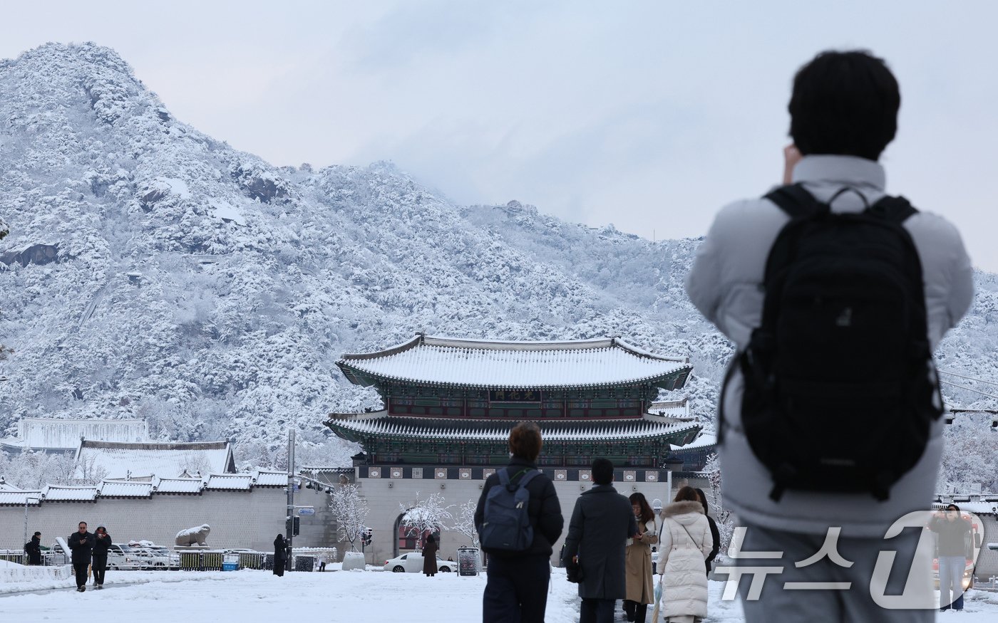 많은 눈이 내린 27일 오전 서울 종로구 광화문광장에서 출근길에 나선 시민이 눈 쌓인 북악산과 광화문을 촬영하고 있다. 2024.11.27/뉴스1 ⓒ News1 장수영 기자