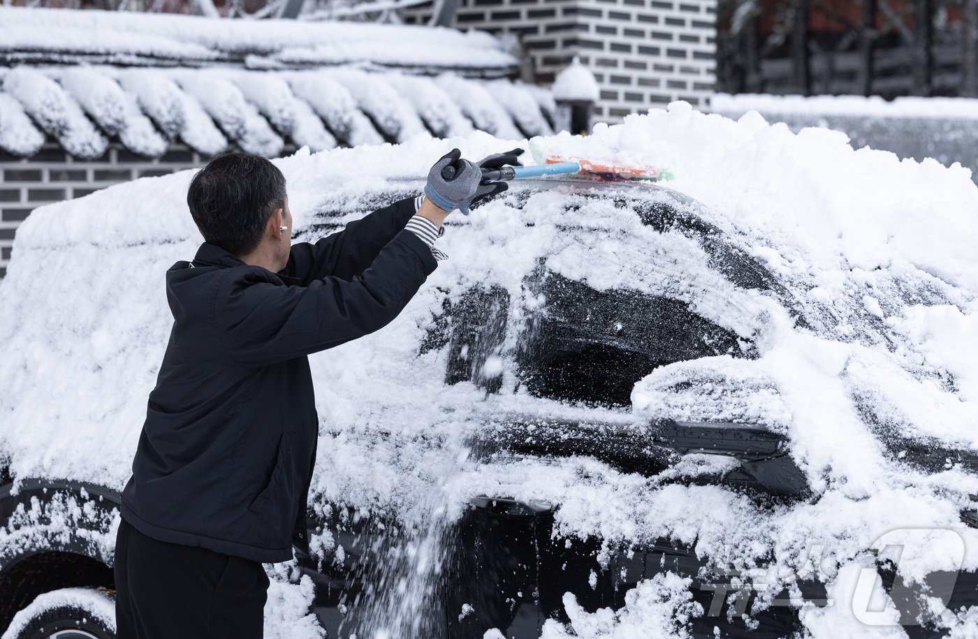 본문 이미지 - 서울 지역에 올해 첫 눈이 내린 27일 오전 서울 종로구 북악스카이웨이 입구 인근에서 한 시민이 차량에 쌓인 눈을 치우고 있다. 2024.11.27/뉴스1 ⓒ News1 이재명 기자
