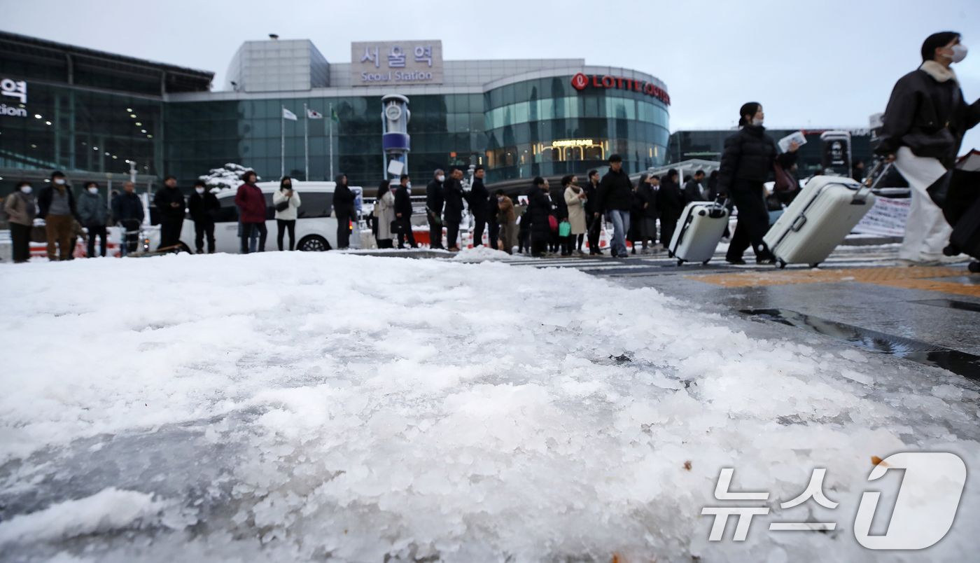 (서울=뉴스1) 오대일 기자 = 수도권과 강원지역을 중심으로 대설 특보가 발효된 27일 오전 서울 중구 서울역 앞 택시 승강장에서 시민들이 택시를 기다리며 길게 줄을 늘어서 있다. …