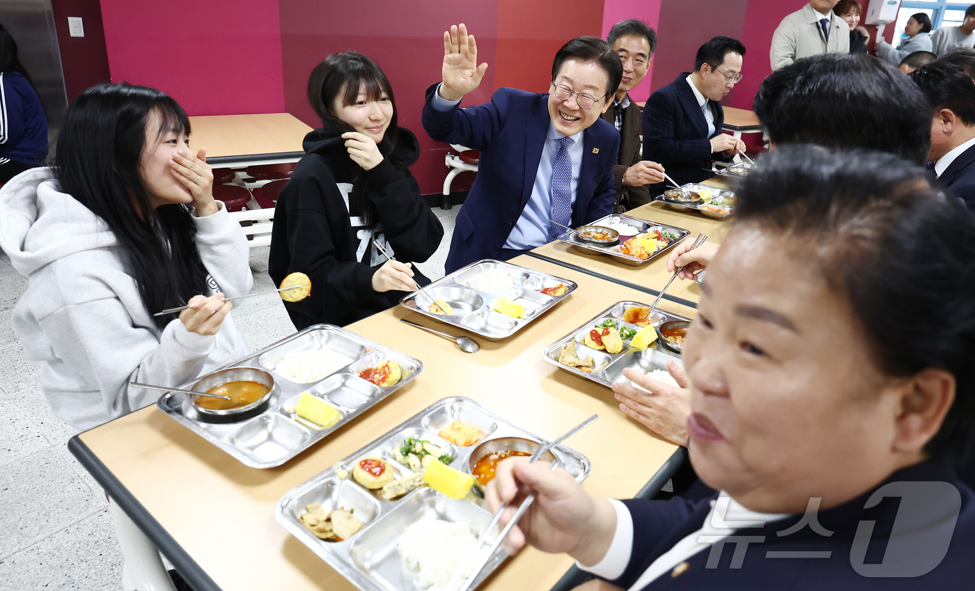 (서울=뉴스1) 김민지 기자 = 이재명 더불어민주당 대표가 27일 서울 성동구 금호고등학교에서 열린 고교 무상교육을 위한 현장 간담회를 마치고 급식을 먹던 도중 학생들을 향해 손인 …