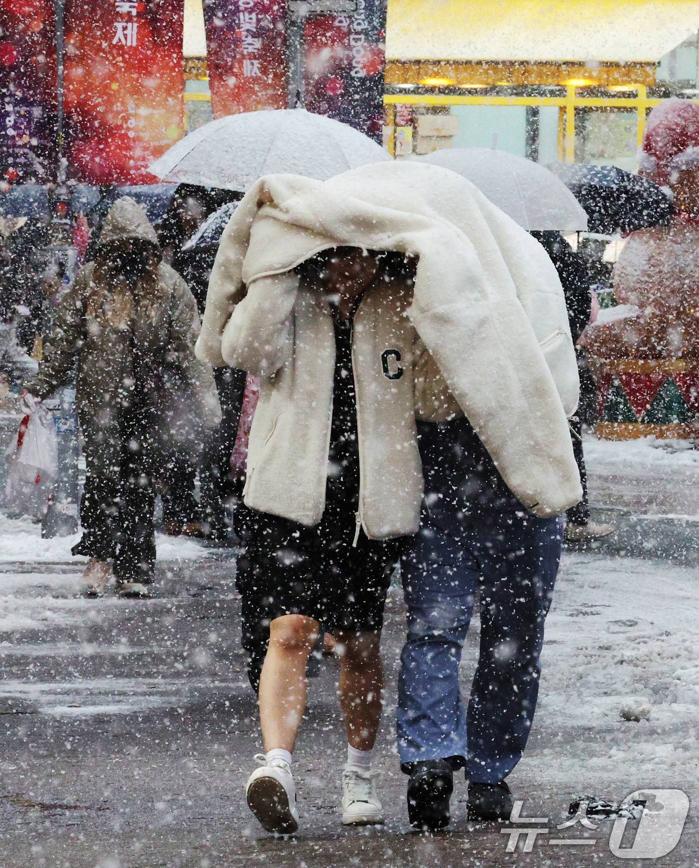 (서울=뉴스1) 장수영 기자 = 많은 눈이 내린 27일 오후 서울 명동에서 관광객들이 발걸음을 재촉하고 있다.기상청은 기상관측을 시작한 이래 11월 가장 많은 눈이 내렸다고 밝혔다 …