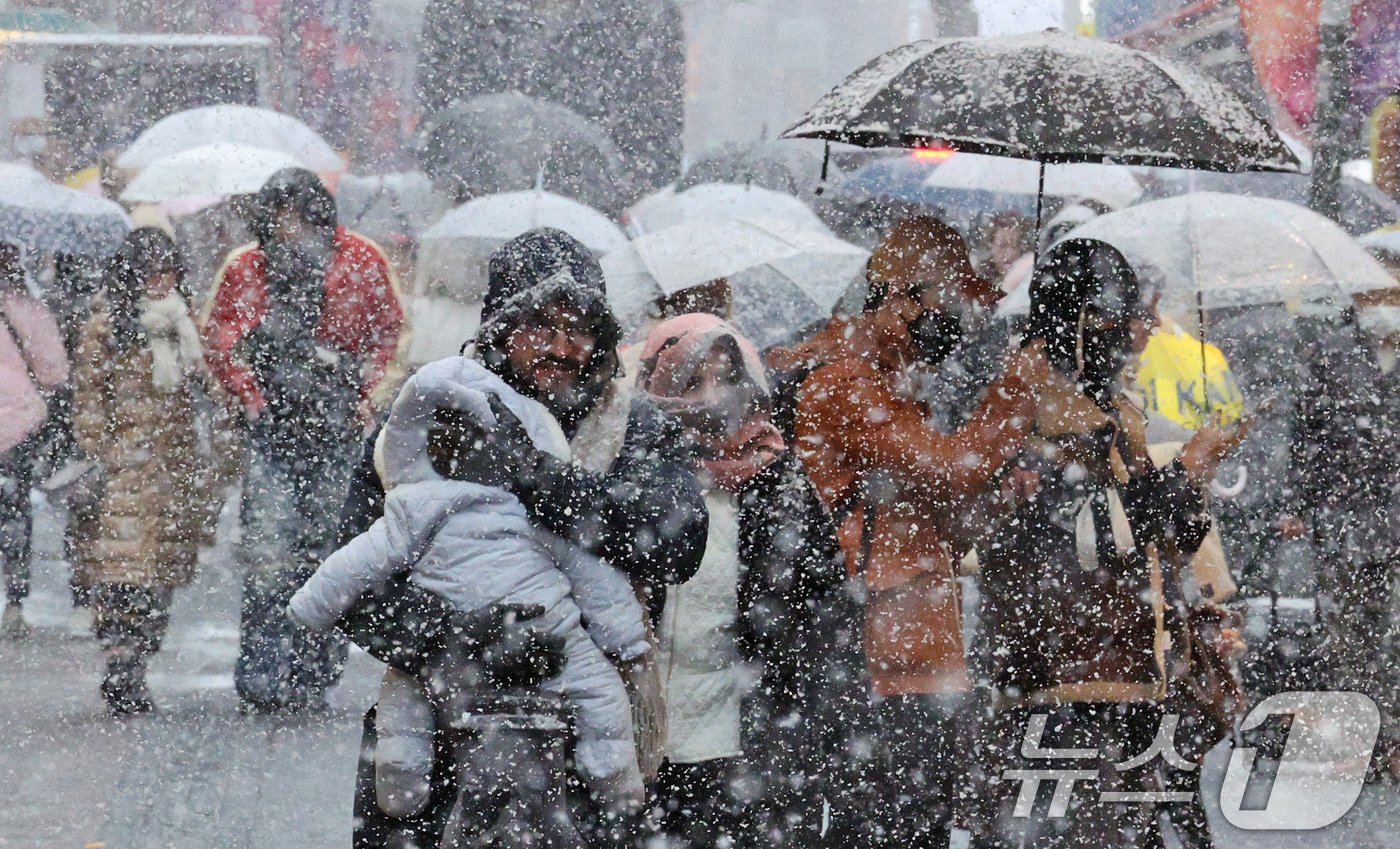 본문 이미지 - 많은 눈이 내린 27일 오후 서울 명동에서 외국인 관광객들이 발걸음을 재촉하고 있다. 기상청은 기상관측을 시작한 이래 11월 가장 많은 눈이 내렸다고 밝혔다. 2024.11.27/뉴스1 ⓒ News1 장수영 기자