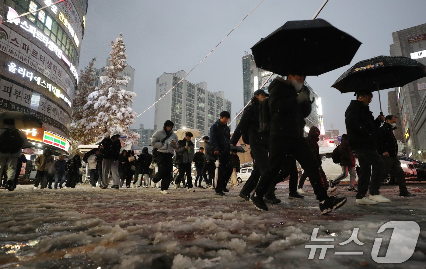 서울을 비롯한 수도권에 기록적인 폭설이 쏟아진 27일 오후 경기 수원시 영통구 망포역 사거리에서 퇴근길에 오른 시민들이 발걸음을 재촉하고 있다. 2024.11.27/뉴스1 ⓒ News1 김영운 기자