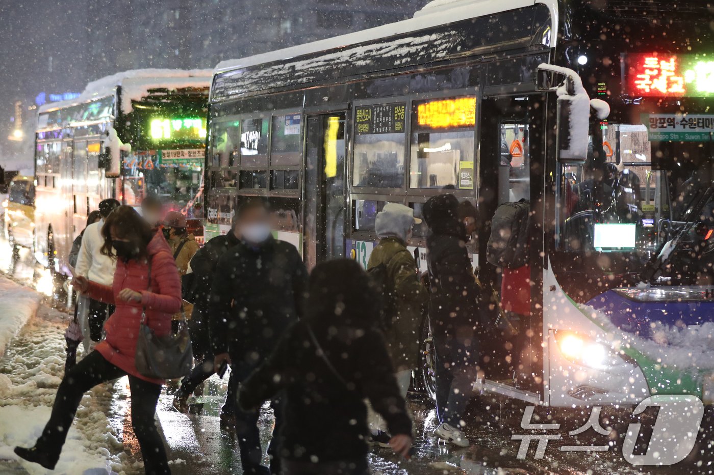 본문 이미지 - 서울을 비롯한 수도권에 기록적인 폭설이 쏟아진 27일 오후 경기 수원시 영통구 망포역 사거리에서 퇴근길에 오른 시민들이 발걸음을 재촉하고 있다. 2024.11.27/뉴스1 ⓒ News1 김영운 기자
