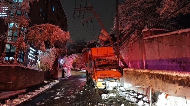 서울 성북구 내리막길 미끄러진 제설차 전신주 들이받아 한때 정전