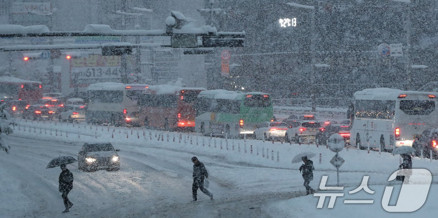 본문 이미지 - 서울을 비롯한 수도권에 기록적인 폭설이 쏟아진 28일 오전 경기 화성시의 한 횡단보도에서 출근길에 오른 시민들이 발걸음을 옮기고 있다. 2024.11.28/뉴스1 ⓒ News1 김영운 기자