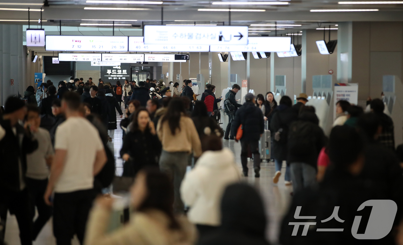 (김포공항=뉴스1) 이승배 기자 = 밤 사이 전국 대부분 지역에 많은 눈이 내려 항공기 지연 및 결항이 속출하는 28일 김포공항 국내선 탑승수속 층이 탑승객들로 북적이고 있다. 2 …