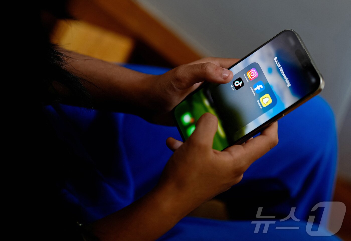 본문 이미지 - 호주의 한 고등학생이 스마트폰으로 소셜 미디어 어플리케이션 화면을 보고 있다. ⓒ 로이터=뉴스1