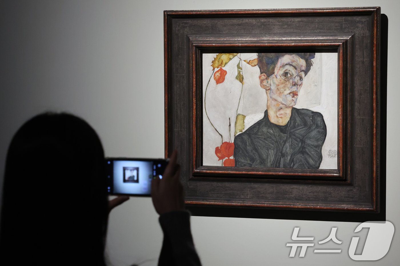 본문 이미지 - 29일 오전 서울 용산구 국립중앙박물관에서 열린 '비엔나 1900, 꿈꾸는 예술가들-구스타프 클림트부터 에곤 실레까지' 언론공개회에서 관계자가 에곤 실레의 '꽈리 열매가 있는 자화상'을 살펴보고 있다. 이번 전시회에는 오스트리아 레오폴미술관의 대표 소장품 중 191점이 관람객에게 소개된다. 2024.11.29/뉴스1 ⓒ News1 황기선 기자