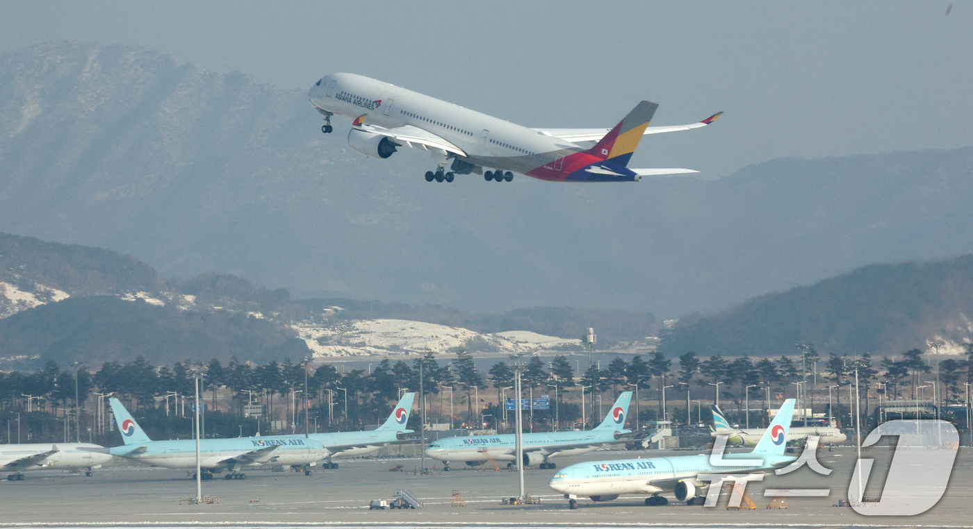 (인천공항=뉴스1) 장수영 기자 = 29일 오전 인천국제공항에서 아시아나 항공기가 대한항공 항공기 위로 이륙하고 있다.대한항공은 지난 28일 유럽연합 집행위원회(EC)가 대한항공과 …