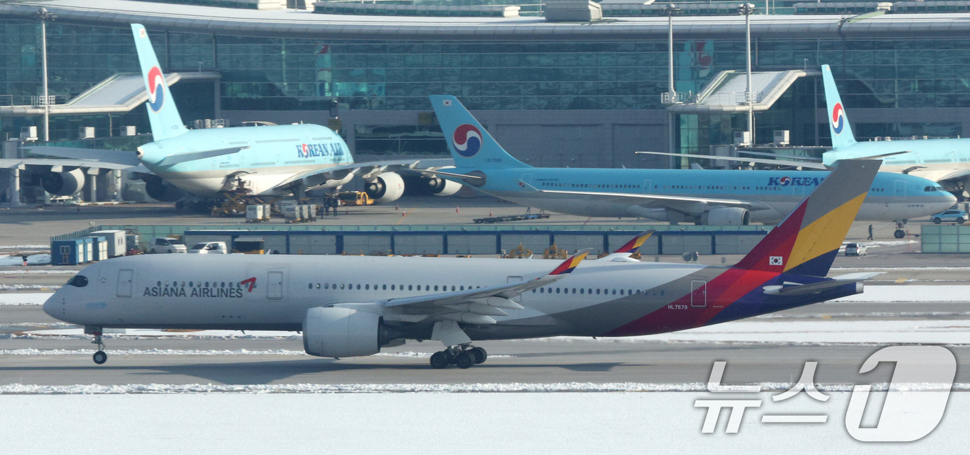 (인천공항=뉴스1) 장수영 기자 = 29일 오전 인천국제공항에서 아시아나 항공기가 대한항공 항공기 앞으로 지나가고 있다.대한항공은 지난 28일 유럽연합 집행위원회(EC)가 대한항공 …