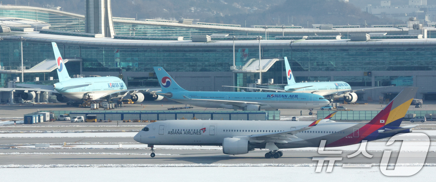 (인천공항=뉴스1) 장수영 기자 = 29일 오전 인천국제공항에서 아시아나 항공기가 대한항공 항공기 앞으로 지나가고 있다.대한항공은 지난 28일 유럽연합 집행위원회(EC)가 대한항공 …