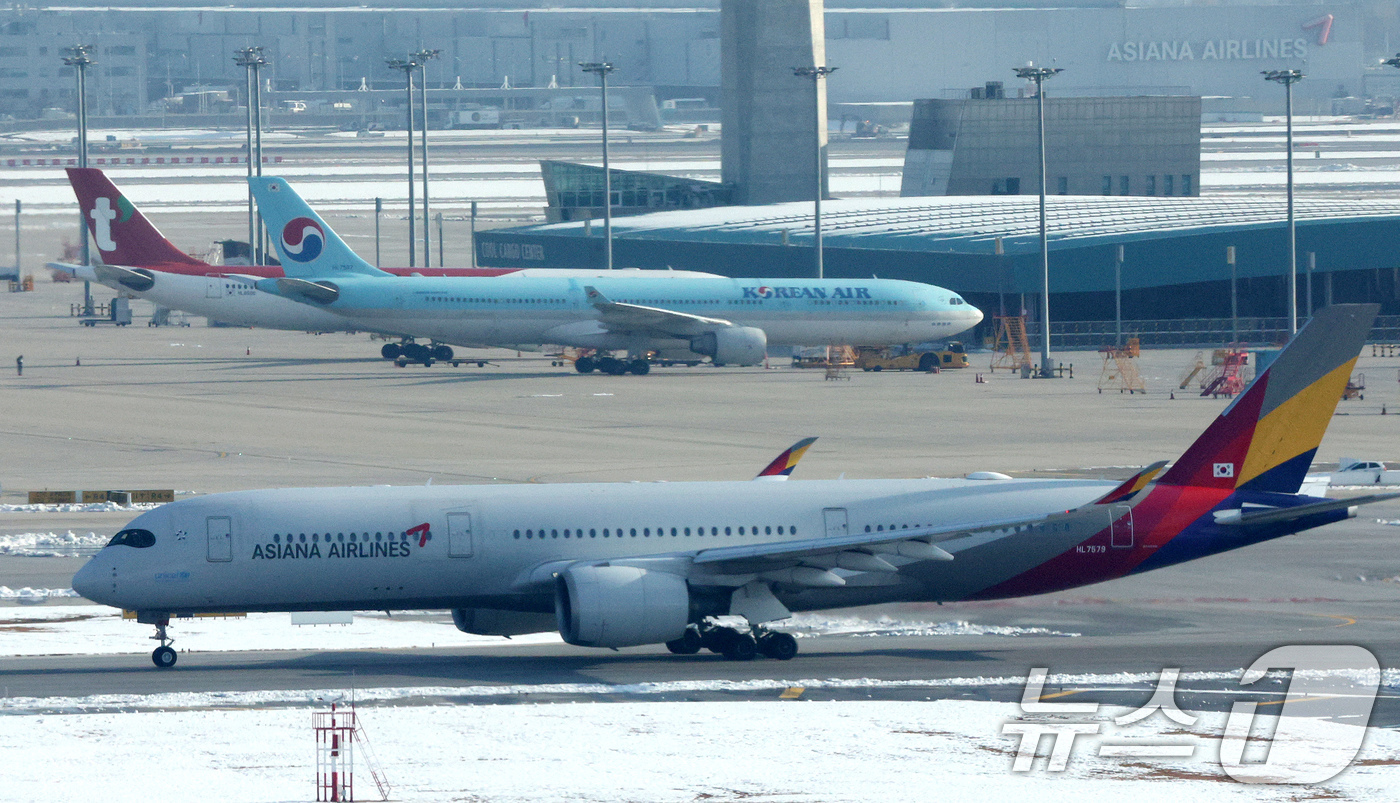 (인천공항=뉴스1) 장수영 기자 = 29일 오전 인천국제공항에서 아시아나 항공기가 대한항공 항공기 앞으로 지나가고 있다.대한항공은 지난 28일 유럽연합 집행위원회(EC)가 대한항공 …