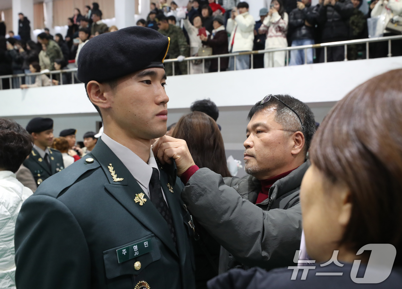 (경기광주=뉴스1) 김영운 기자 = 29일 오전 경기 광주시 육군 특수전학교에서 열린 '특전부사관 257기 임관식'에서 가족들이 신임 특전부사관들에게 하사 계급장 수여를 하고 있다 …