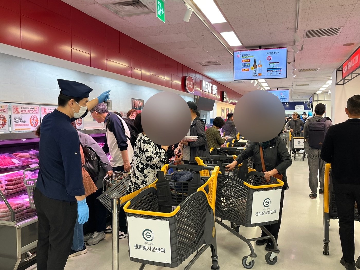 본문 이미지 -  3일 오전 서울 이마트 용산점 정육 코너에서 고객들이 반값 한우를 담고 있는 모습. 