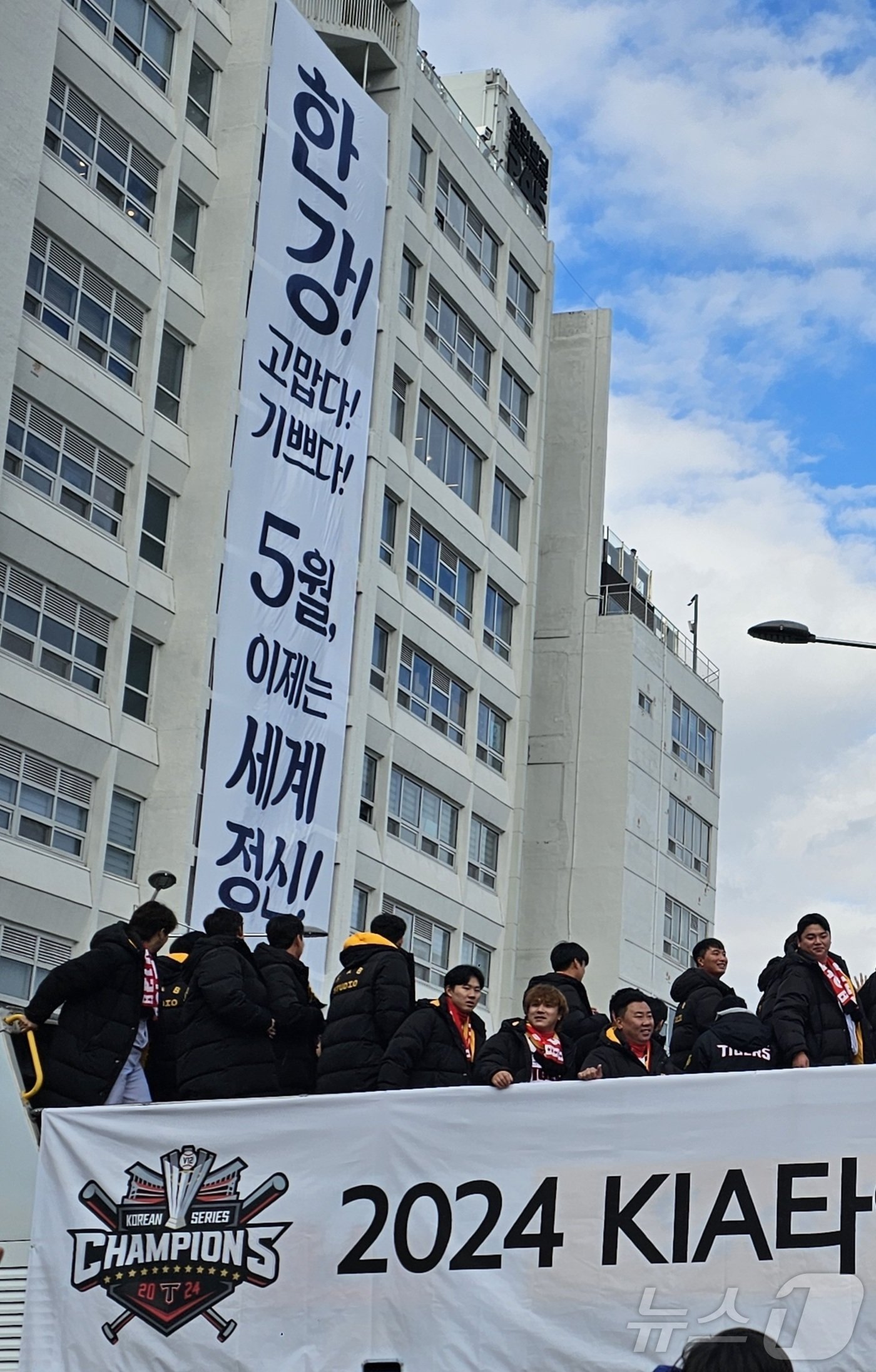 본문 이미지 - 광주시와 기아 타이거즈가 프로야구 한국시리즈 통산 12번째 우승을 축하하며 30일 오후 광주 동구 금남로에서 카퍼레이드를 하는 가운데 광주 출신 한강 작가의 노벨문학상 수상을 축하하는 현수막이 걸린 전일빌딩을 지나고 있다.2024.11.30./뉴스1 ⓒ News1 서충섭 기자