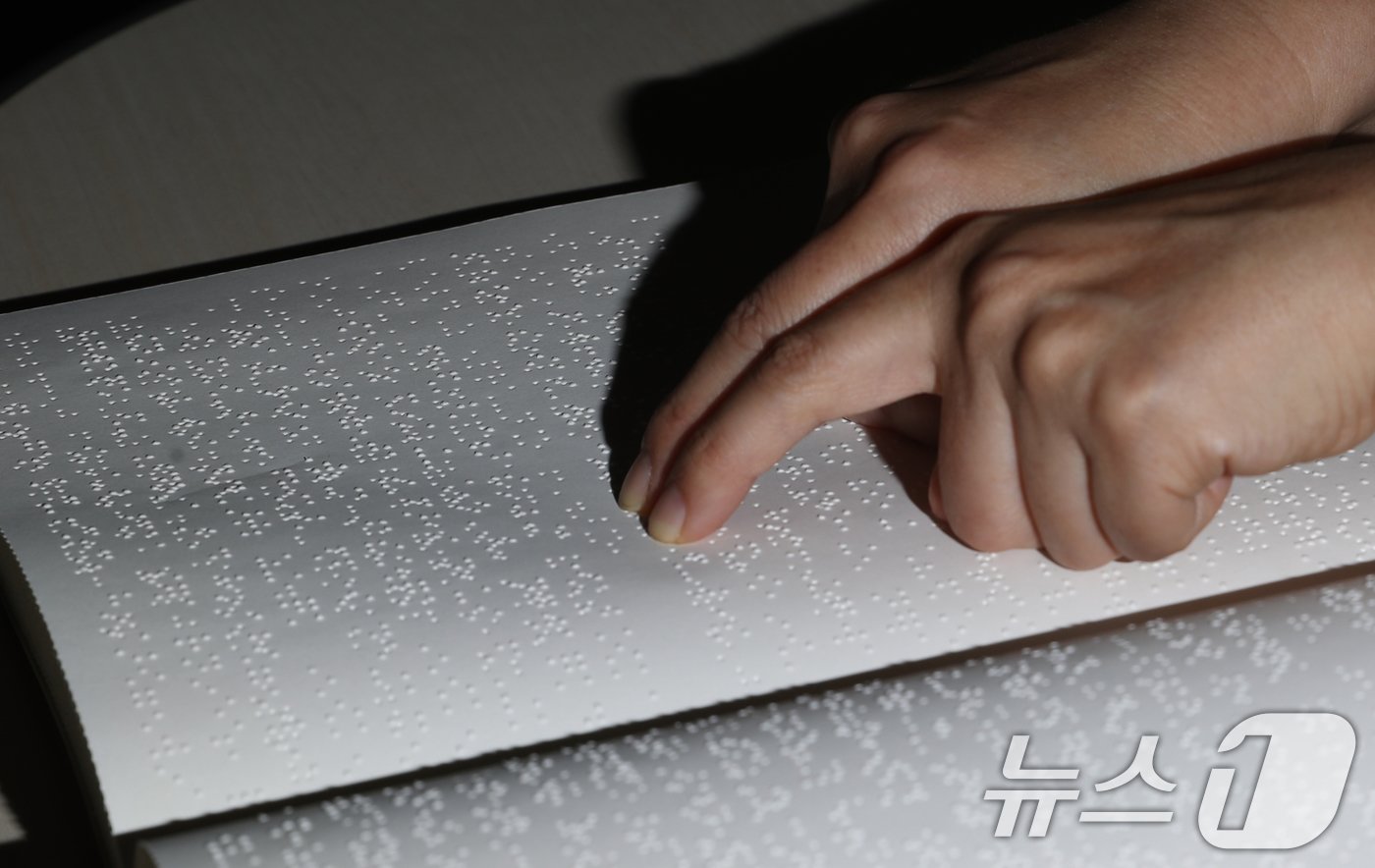 본문 이미지 - '점자의 날'인 4일 오후 경기 수원시 영통구 사랑샘도서관에서 관계자가 점자책을 읽고 있다. ‘점자의 날’은 시각장애인의 세종대왕이라 불리는 송암 박두성 선생이 시각장애인을 위한 한글 점자를 만들어 반포한 1926년 11월 4일을 기념하는 날이다. 2024.11.4/뉴스1 ⓒ News1 김영운 기자