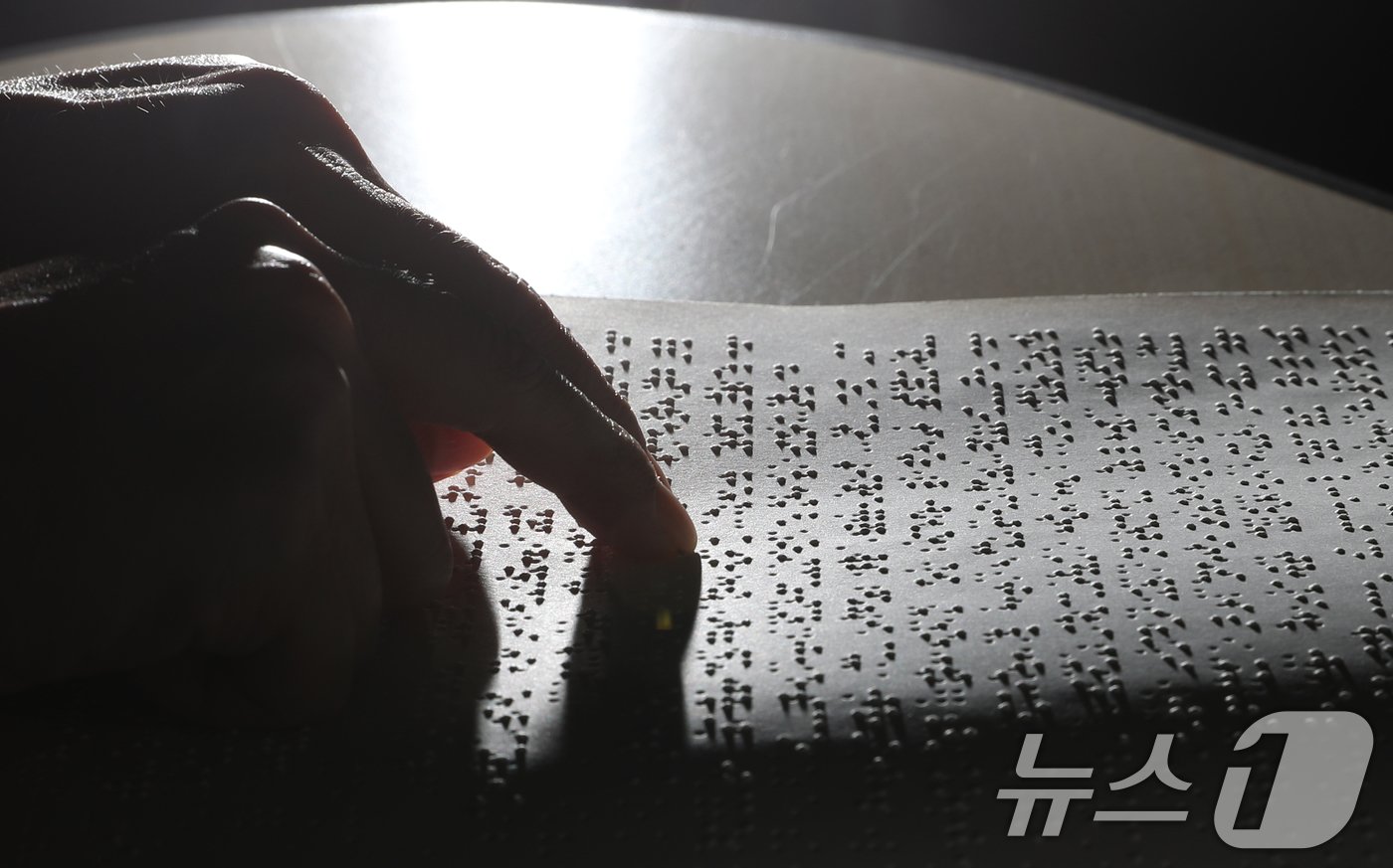 본문 이미지 - '점자의 날'인 4일 오후 경기 수원시 영통구 사랑샘도서관에서 관계자가 점자책을 읽고 있다. ‘점자의 날’은 시각장애인의 세종대왕이라 불리는 송암 박두성 선생이 시각장애인을 위한 한글 점자를 만들어 반포한 1926년 11월 4일을 기념하는 날이다. 2024.11.4/뉴스1 ⓒ News1 김영운 기자