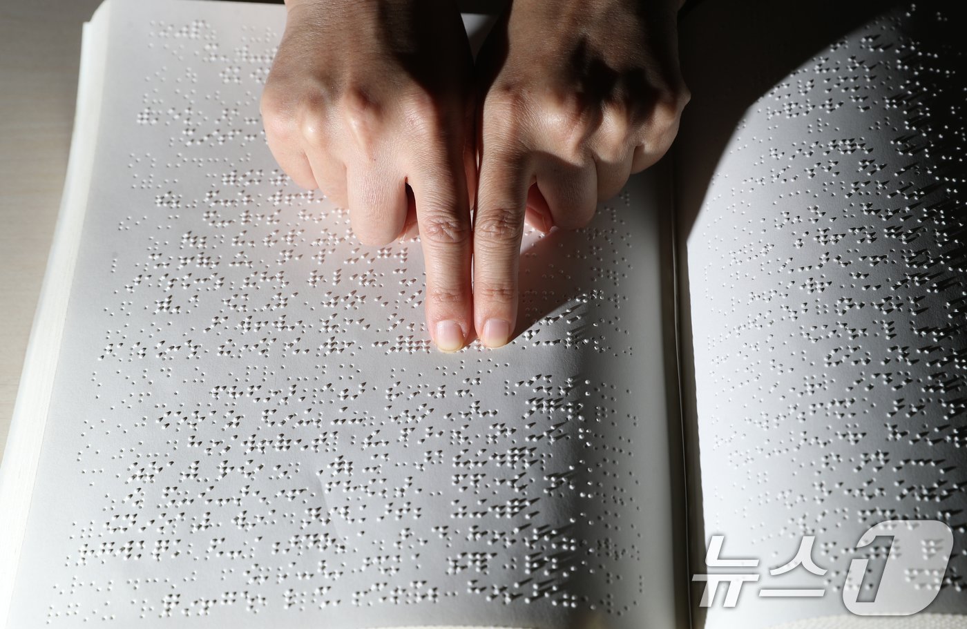 본문 이미지 - '점자의 날'인 4일 오후 경기 수원시 영통구 사랑샘도서관에서 관계자가 점자책을 읽고 있다. ‘점자의 날’은 시각장애인의 세종대왕이라 불리는 송암 박두성 선생이 시각장애인을 위한 한글 점자를 만들어 반포한 1926년 11월 4일을 기념하는 날이다. 2024.11.4/뉴스1 ⓒ News1 김영운 기자