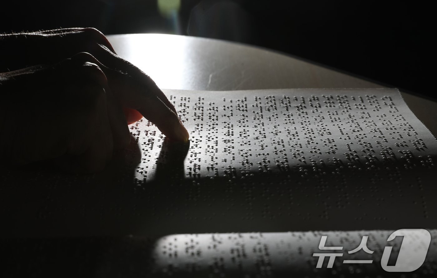 본문 이미지 - '점자의 날'인 4일 오후 경기 수원시 영통구 사랑샘도서관에서 관계자가 점자책을 읽고 있다. ‘점자의 날’은 시각장애인의 세종대왕이라 불리는 송암 박두성 선생이 시각장애인을 위한 한글 점자를 만들어 반포한 1926년 11월 4일을 기념하는 날이다. 2024.11.4/뉴스1 ⓒ News1 김영운 기자