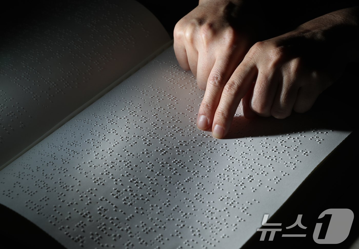 본문 이미지 - '점자의 날'인 4일 오후 경기 수원시 영통구 사랑샘도서관에서 관계자가 점자책을 읽고 있다. ‘점자의 날’은 시각장애인의 세종대왕이라 불리는 송암 박두성 선생이 시각장애인을 위한 한글 점자를 만들어 반포한 1926년 11월 4일을 기념하는 날이다. 2024.11.4/뉴스1 ⓒ News1 김영운 기자