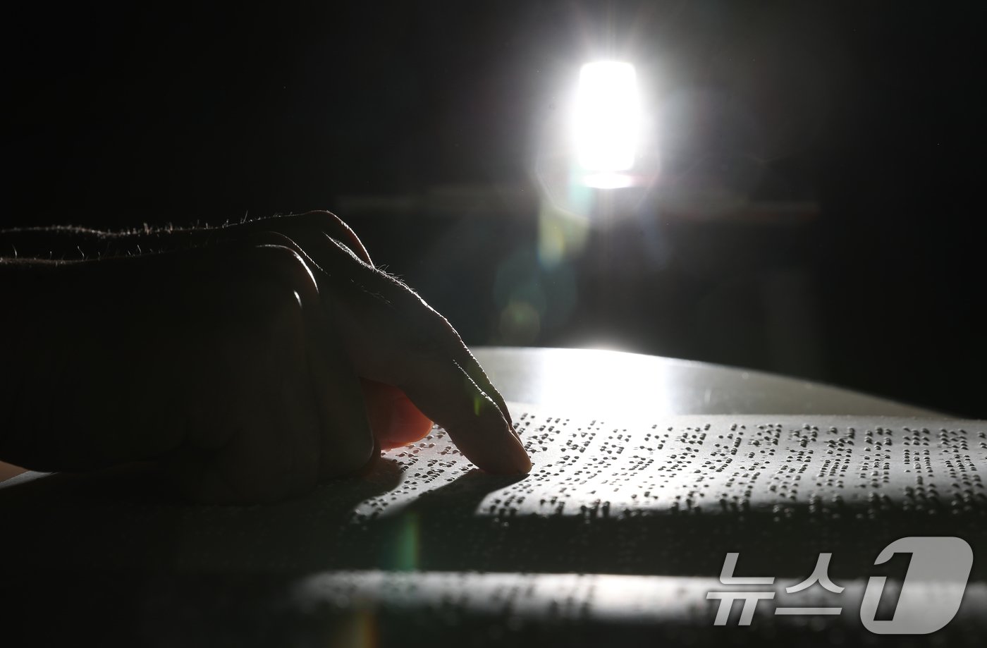 본문 이미지 - '점자의 날'인 4일 오후 경기 수원시 영통구 사랑샘도서관에서 관계자가 점자책을 읽고 있다. ‘점자의 날’은 시각장애인의 세종대왕이라 불리는 송암 박두성 선생이 시각장애인을 위한 한글 점자를 만들어 반포한 1926년 11월 4일을 기념하는 날이다. 2024.11.4/뉴스1 ⓒ News1 김영운 기자