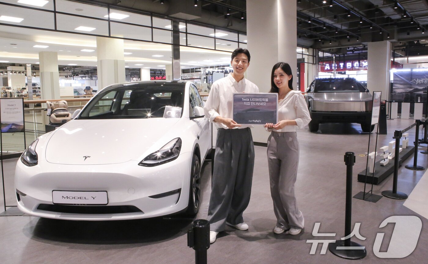 본문 이미지 - 지난해 11월 스타필드 마켓 죽전점 내 '테슬라 팝업스토어'에서 모델들이 테슬라 중형 SUV '모델Y'(왼쪽)를 소개하고 있다.(자료사진. 이마트 제공) 2024.11.4/뉴스1