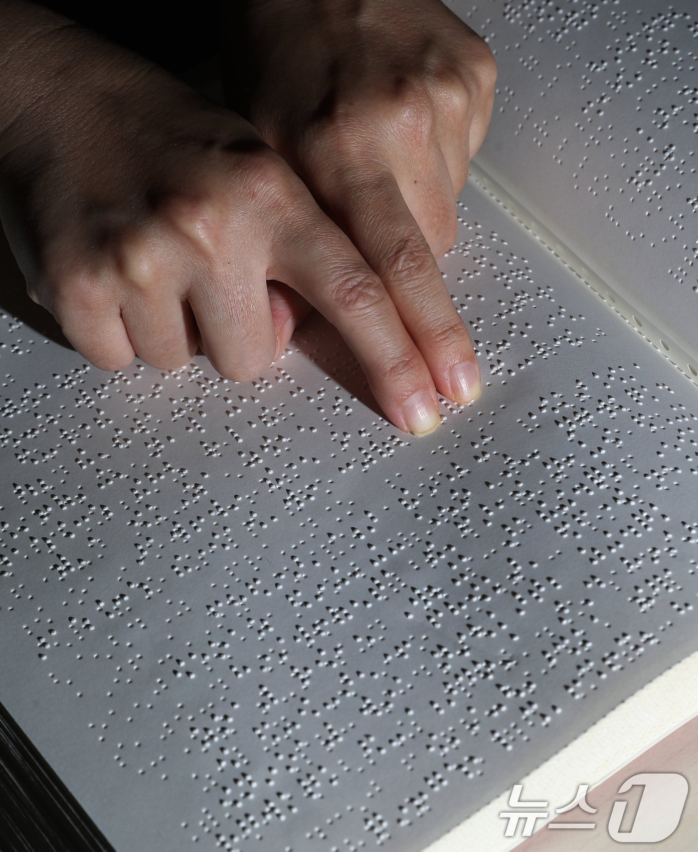 본문 이미지 - '점자의 날'인 4일 오후 경기 수원시 영통구 사랑샘도서관에서 관계자가 점자책을 읽고 있다. ‘점자의 날’은 시각장애인의 세종대왕이라 불리는 송암 박두성 선생이 시각장애인을 위한 한글 점자를 만들어 반포한 1926년 11월 4일을 기념하는 날이다. 2024.11.4/뉴스1 ⓒ News1 김영운 기자