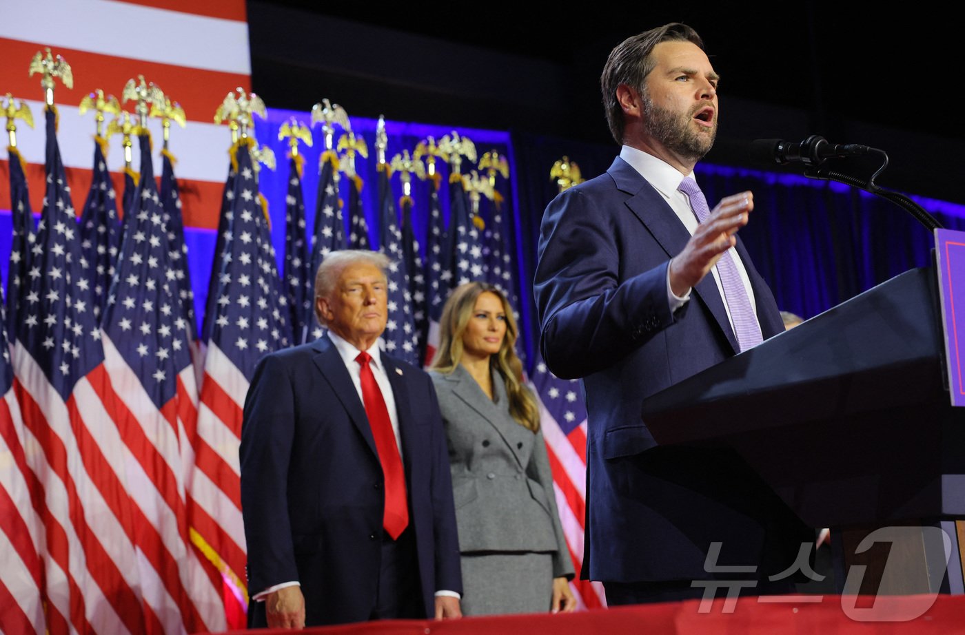 본문 이미지 - 6일(현지시간) 플로리다주 웨스트팜비치의 팜비치카운티 컨벤션센터에서 대통령 당선이 유력한 공화당 대선후보 도널드 트럼프 전 대통령과 아내인 멜라니아 트럼프 여사가 지켜보는 가운데, 그의 러닝메이트인 JD 밴스 상원의원이 지지자들 앞에서 연설하고 있다. 2024.11.06 ⓒ 로이터=뉴스1 ⓒ News1 김지완 기자