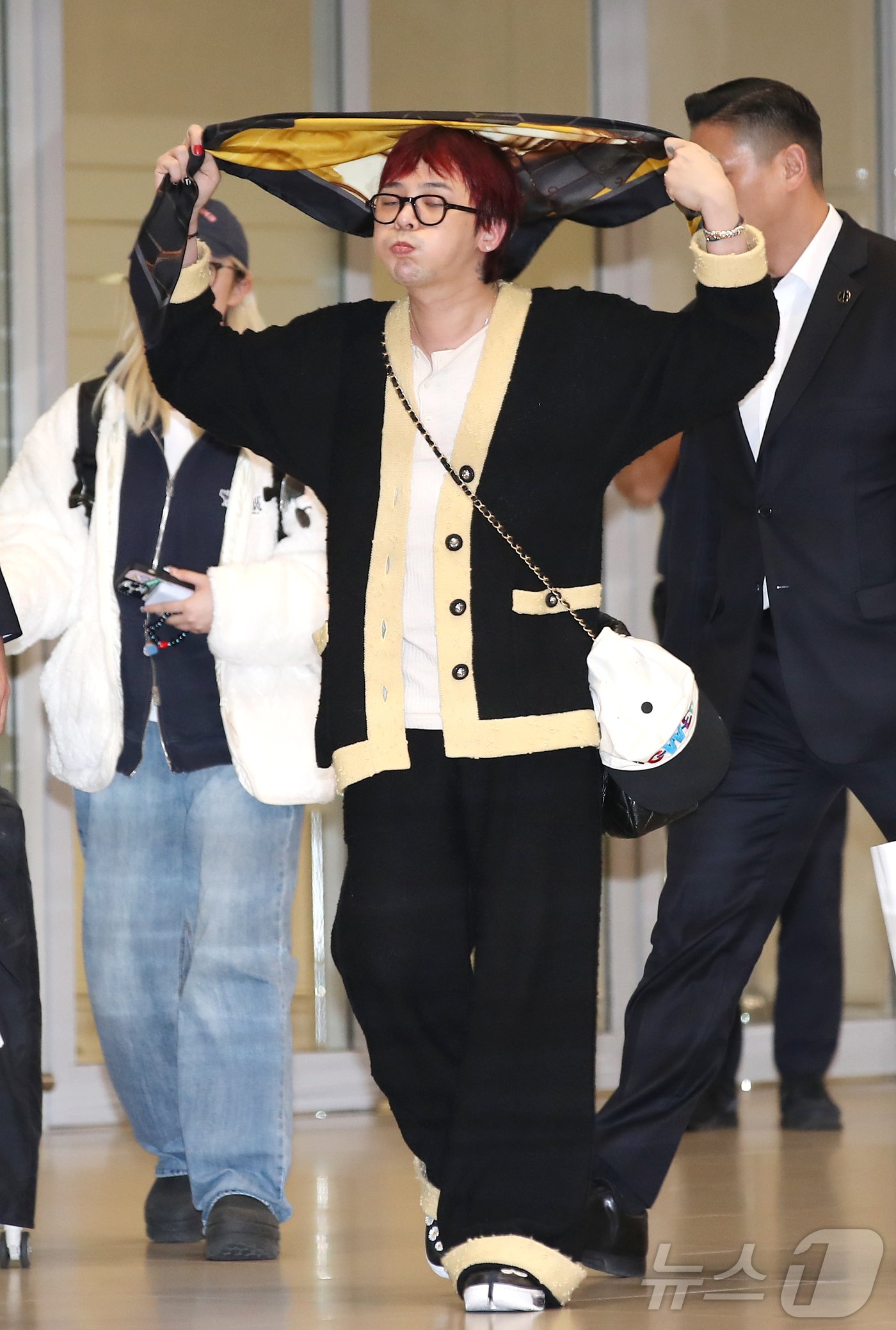 본문 이미지 - 빅뱅 지드래곤&#40;GD&#41;이 7일 인천국제공항에 도착해 스카프를 매며 귀국하고 있다. ⓒ News1 권현진 기자