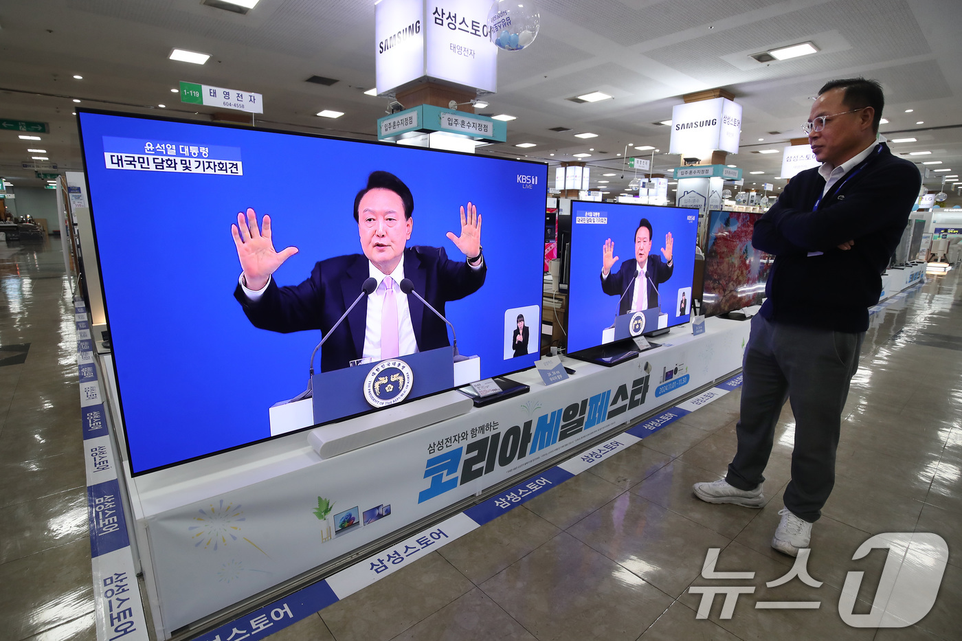 (대구=뉴스1) 공정식 기자 = 7일 오전 대구 북구 유통단지 전자관에서 시민들이 윤석열 대통령의 대국민담화 및 기자회견을 시청하고 있다. 2024.11.7/뉴스1