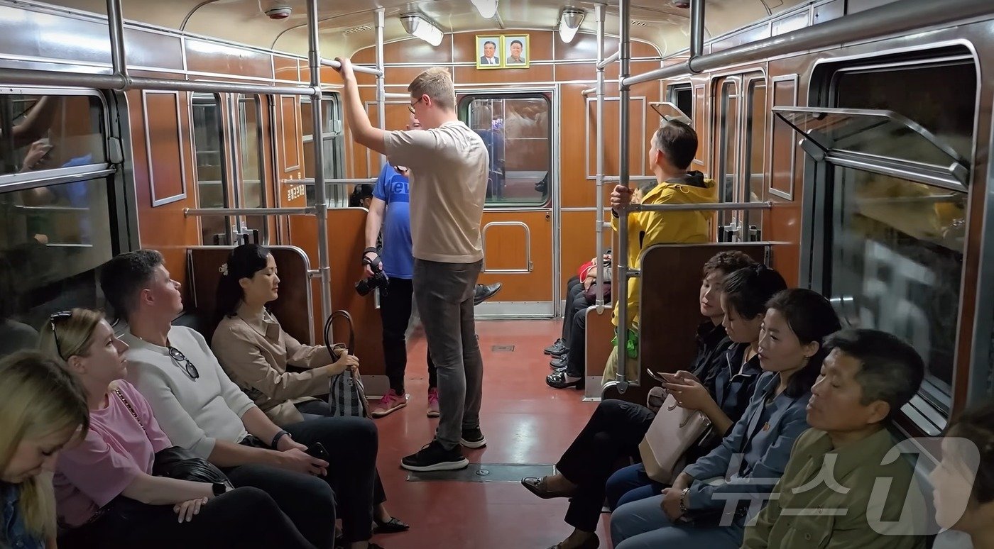 본문 이미지 - 평양 천리마선 열차 내부 모습. 대체로 한국과 비슷하지만 한쪽 벽에 전 국가주석들의 초상화가 나란히 걸려있는 것을 확인할 수 있다. (출처 유튜브 'PoletMe Aviation Videos')