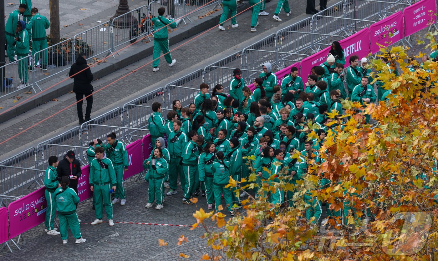 본문 이미지 - 11일(현지시간) 프랑스 파리 샹젤리제 거리에서 열린 넷플릭스 오리지널 시리즈 ‘오징어게임’ 재현 현장 이벤트에서 참가자들이 드라마 속 게임인 ‘무궁화꽃이 피었습니다’에 참여하고 있다.  2024.12.2/뉴스1 ⓒ News1 이준성 기자