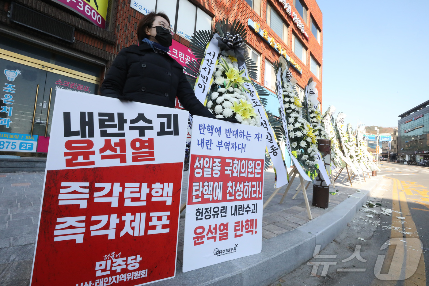 (서산=뉴스1) 김기남 기자 = 10일 오후 한 시민이 윤석열 대통령 탄핵소추안 표결에 불참한 국민의힘 성일종(충남 서산·태안) 국회의원의 충남 서산시 사무실  앞에서 1인 시위를 …