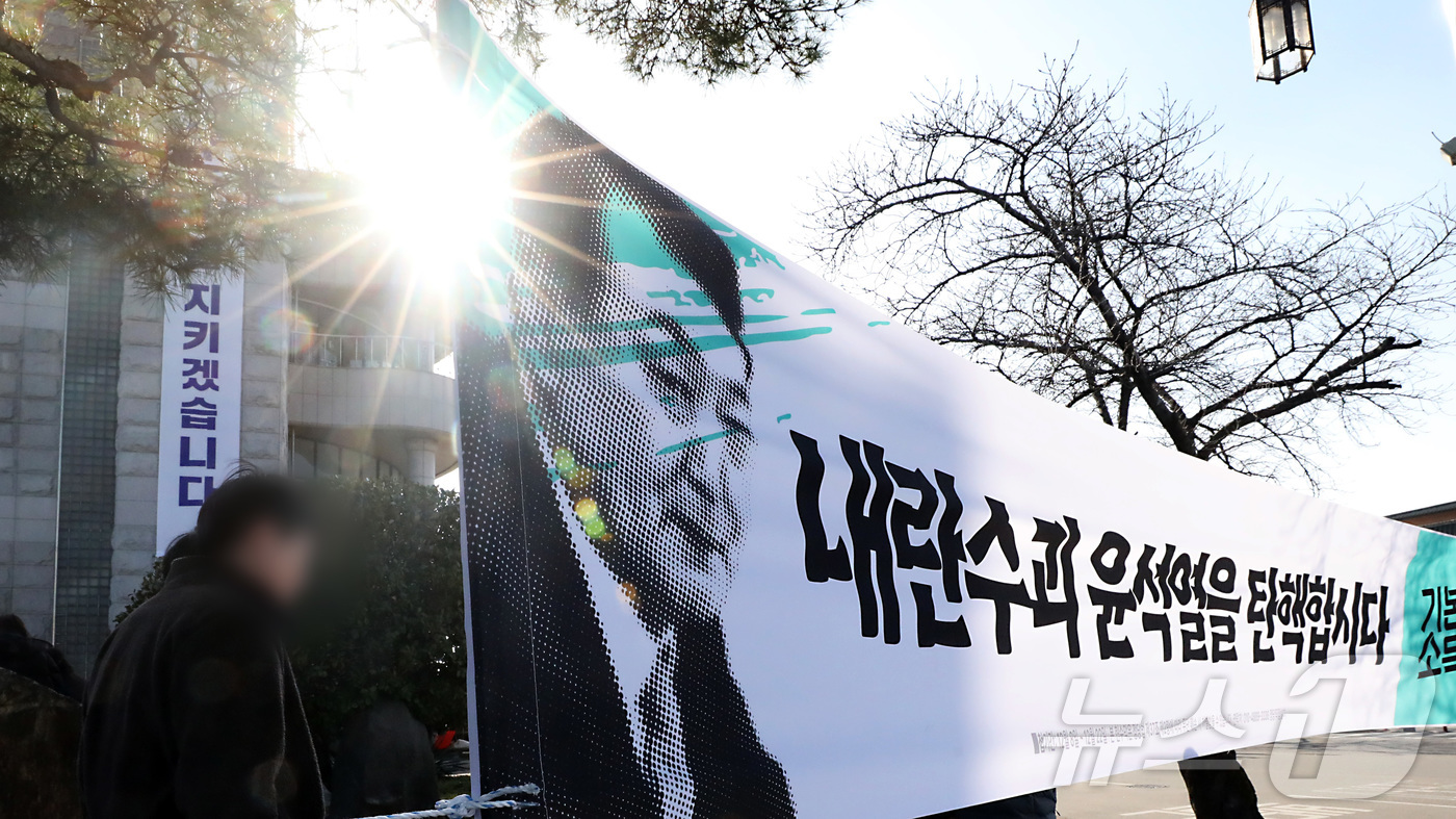 (부여=뉴스1) 김기남 기자 = 10일 오후 충남 부여군청 앞을 지나는 시민들이 윤석열 대통령의 탄핵을 요구하는 플래카드를 지나고 있다.  . 2024.12.10/뉴스1