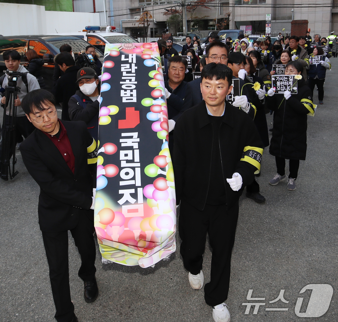 (부산=뉴스1) 윤일지 기자 = 윤석열 정권 퇴진 부산비상행동 구성원들이 11일 오후 부산 수영구 국민의힘 부산시당 앞에서 '내란공범 국민의힘 사망선고 장례식 기자회견'을 한 뒤 …