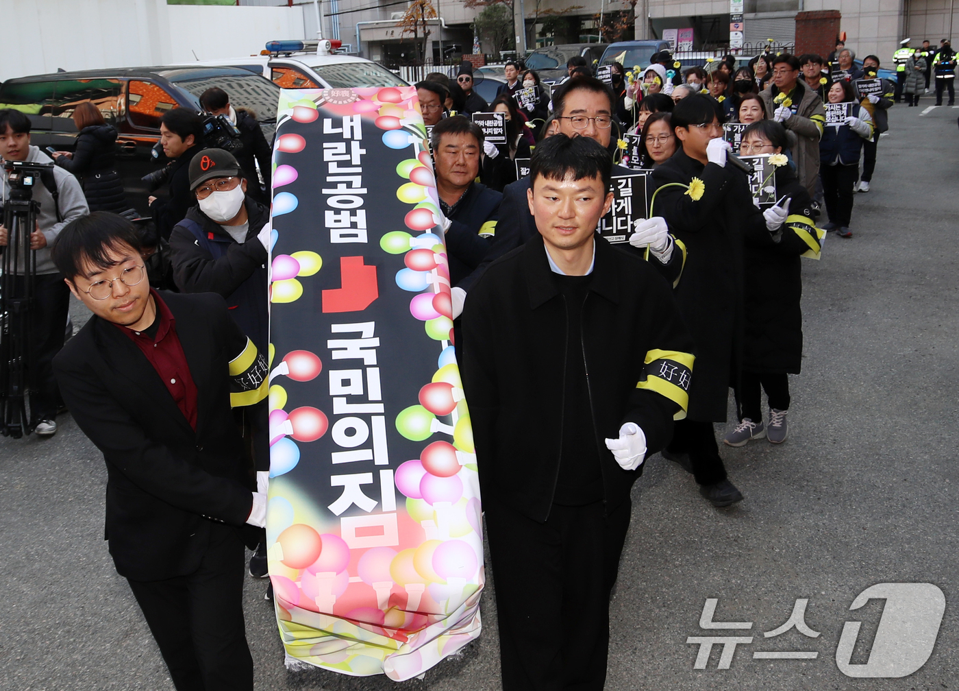 (부산=뉴스1) 윤일지 기자 = 윤석열 정권 퇴진 부산비상행동 구성원들이 11일 오후 부산 수영구 국민의힘 부산시당 앞에서 '내란공범 국민의힘 사망선고 장례식 기자회견'을 한 뒤 …