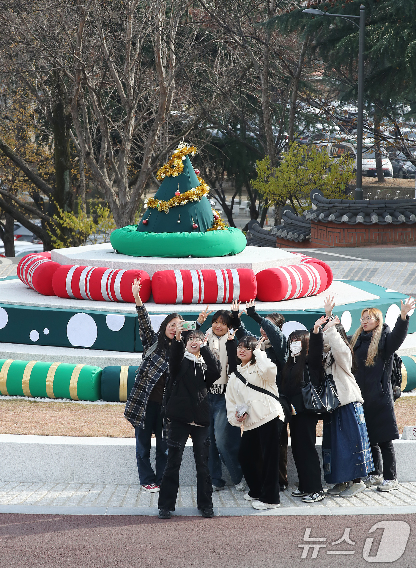 (대구=뉴스1) 공정식 기자 = 11일 대구 남구 계명대학교 대명캠퍼스 정문 분수광장에서 학생들이 크리스마스트리로 변신한 분수대를 배경으로 기념 촬영을 하고 있다.지난 3월 폭염을 …