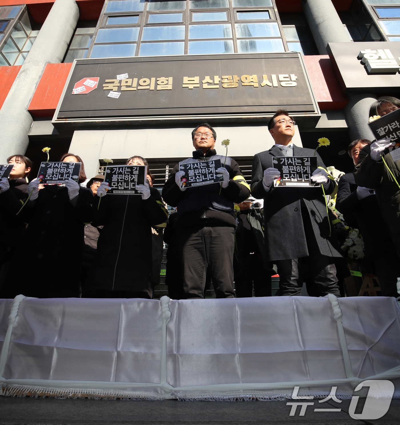 (부산=뉴스1) 윤일지 기자 = 윤석열 정권 퇴진 부산비상행동 구성원들이 11일 오후 부산 수영구 국민의힘 부산시당 앞에서 '내란공범 국민의힘 사망선고 장례식 기자회견'을 하고 있 …