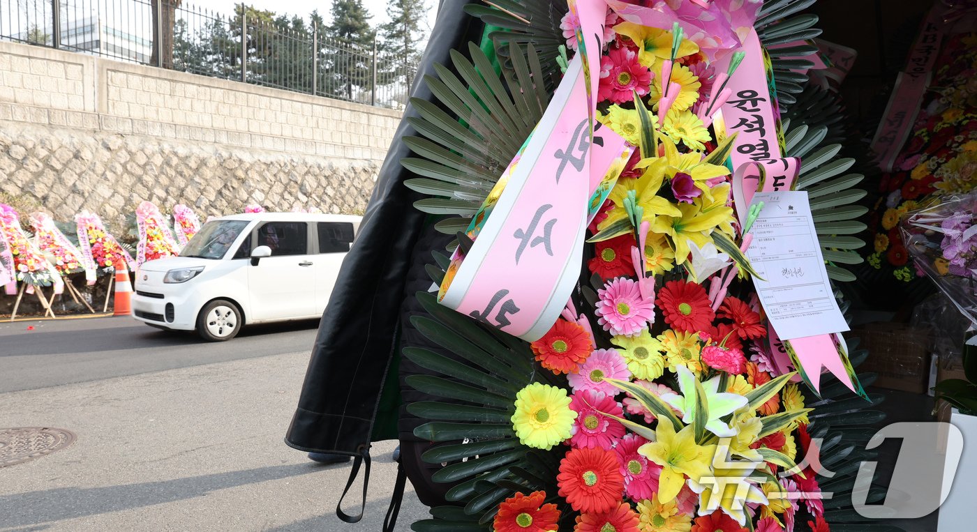 본문 이미지 - 11일 오후 서울 용산구 대통령실 출입문 앞 도로에 윤석열 대통령 지지자들이 보낸 화환이 놓여져 있다. 2024.12.11/뉴스1 ⓒ News1 장수영 기자