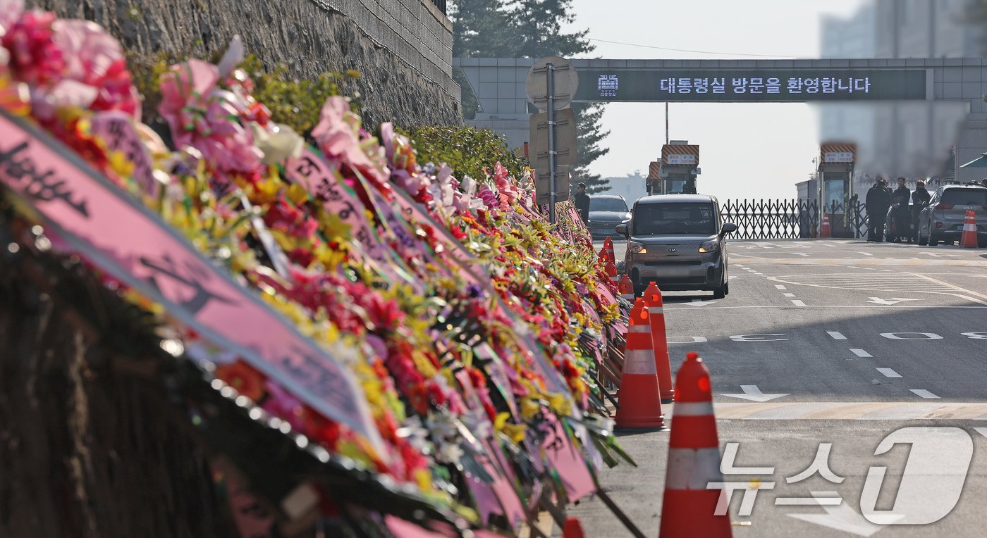 본문 이미지 - 11일 오후 서울 용산구 대통령실 출입문 앞 도로에 윤석열 대통령 지지자들이 보낸 화환이 놓여져 있다. 2024.12.11/뉴스1 ⓒ News1 장수영 기자