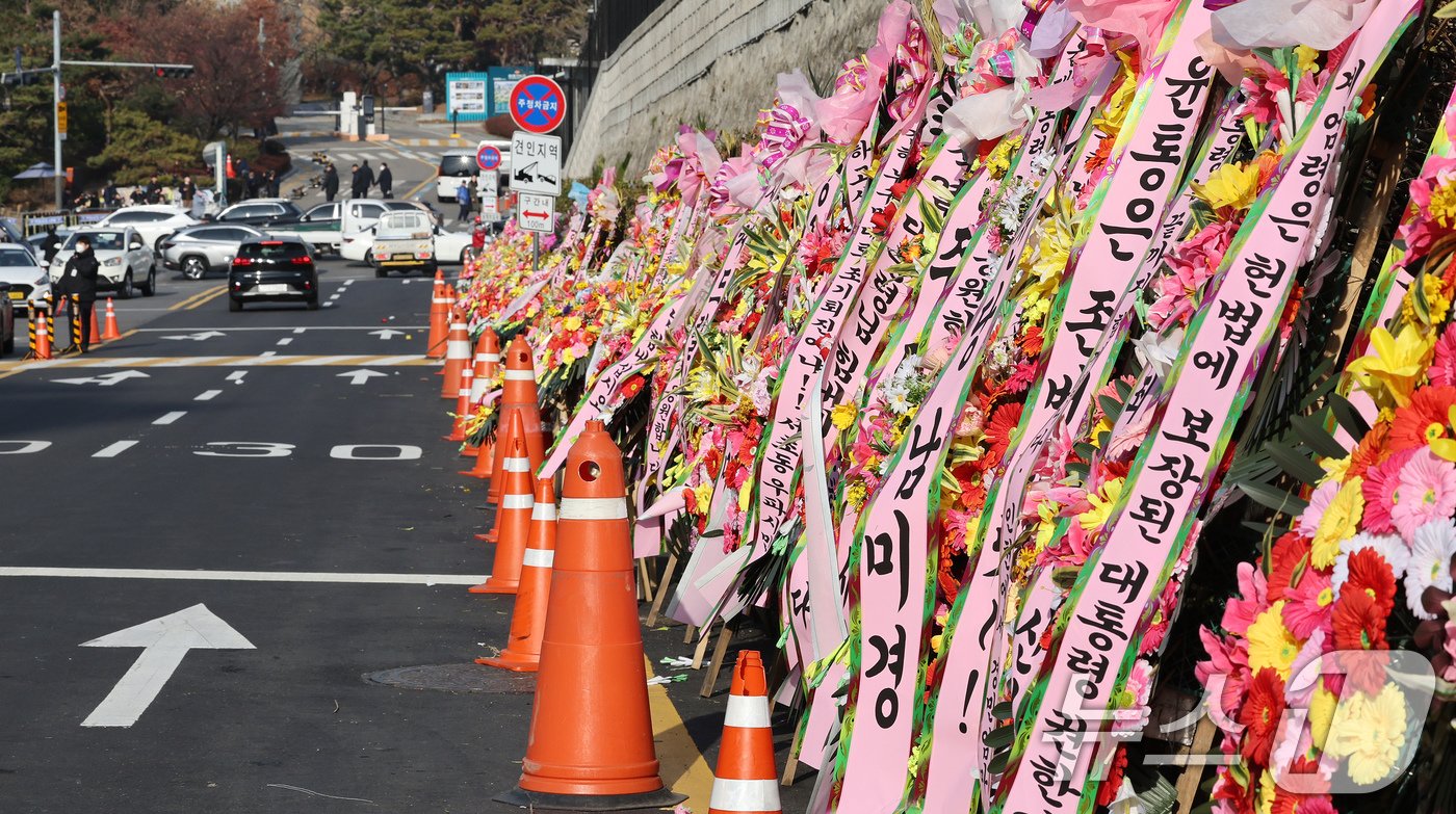 본문 이미지 - 11일 오후 서울 용산구 대통령실 출입문 앞 도로에 윤석열 대통령 지지자들이 보낸 화환이 놓여져 있다. 2024.12.11/뉴스1 ⓒ News1 장수영 기자