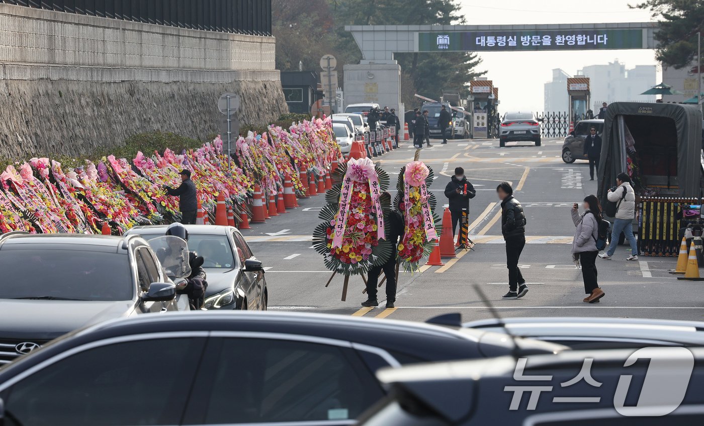 11일 오후 서울 용산구 대통령실 출입문 앞 도로에서 화환 업체 관계자가 윤석열 대통령 지지자들이 보낸 화환을 옮기고 있다. 2024.12.11/뉴스1 ⓒ News1 장수영 기자